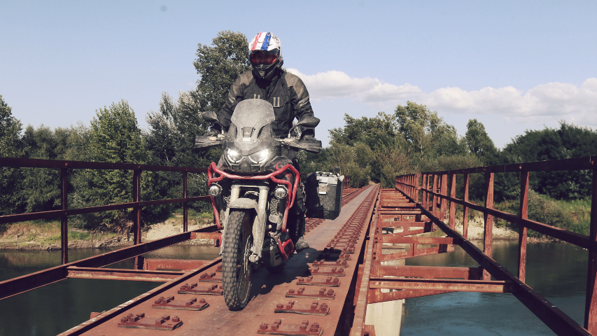 Honda Motorrad fährt über rostige Brücke